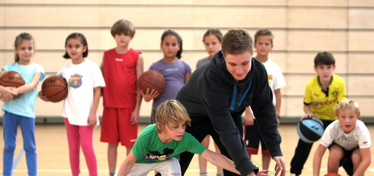 Basics-Trainer Jonathan Gritschke lässt sich vom kleinen Ben den Ball abluchsen. Bei den Basketball-Einsteigern ab sechs Jahren