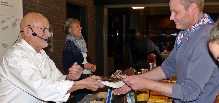 Viele der insgesamt 31 Bücher Rüdiger Nehbergs (links) waren bei seinem Vortrag in Holzmaden sehr gefragt. Foto: Sabine Ackerman