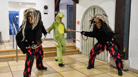 Im Erdgeschoss des Rathauses zerren zwei Deifel die Oberbürgermeisterin aus dem Haus. Im Erdgeschoss des Rathauses zerren zwei Deifel die Oberbürgermeisterin aus dem Haus.