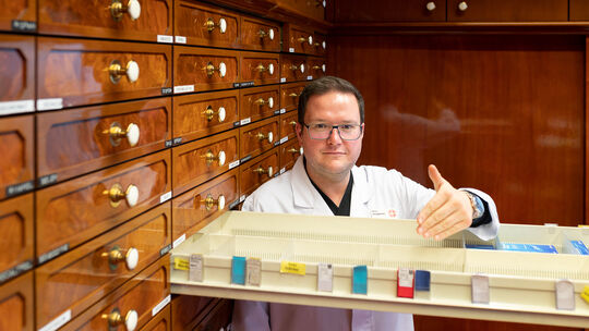 Marco Junghans von der Schneider-Apotheke in Kirchheim zeigt auf den leeren Schubladenteil, in dem sich sonst die Desinfektionsm