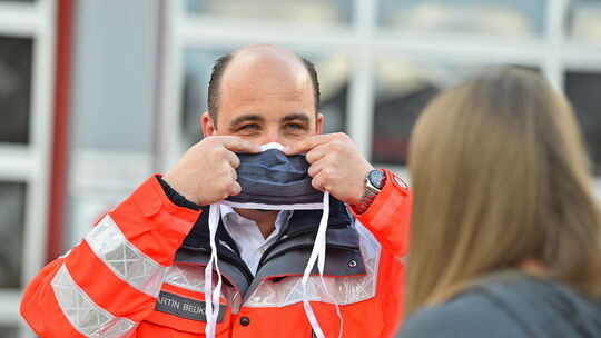 Martin Beuker zeigt, wie man die Maske an der Nase am besten fixiert, damit sie einen sicheren Halt hat. Foto: Markus Brändli