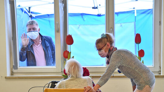 Durch ein schräg gestelltes Fenster konnten Angehörige am Muttertag mit ihren Eltern im Pflegeheim sprechen. Foto: Markus Brändl