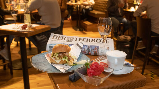 Das Frühstücksangebot zur Feier des Tages: Kaffee, Burger, Teckbote. Als Überraschung servierte Michael Holz (unten mit Plexigla Das Frühstücksangebot zur Feier des Tages: Kaffee, Burger, Teckbote. Als Überraschung servierte Michael Holz (unten mit Plexigla