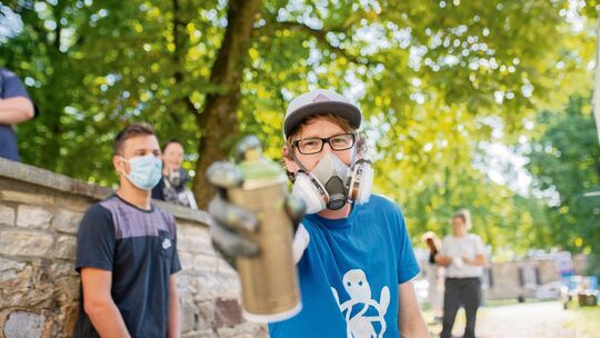 Benjamin Seyfang (kleines Foto) steht mit bunten Sprühdosen und vielen Ideen den Teilnehmern des Workshops mit Rat und Tat zur S