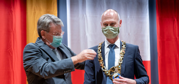 Unter Einhaltung der Corona-Regeln schmückt Stadtrat Christoph Miller Kirchheims Oberbürgermeister Pascal Bader mit der Amtskett