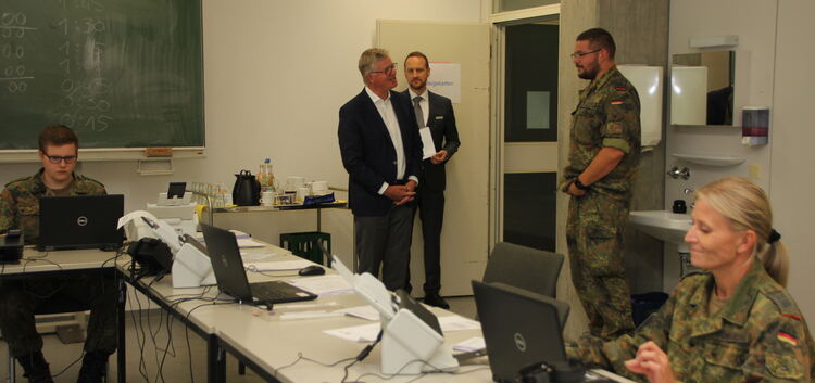 Landrat Heinz Eininger (links) und der Gesundheitsdezernent Christian Baron sind im Gespräch mit Hauptfeldwebel Philipp Linter.