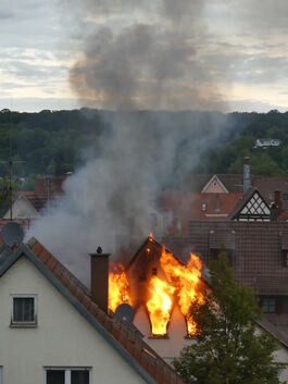 Flammen lodern aus dem brennenden Haus.