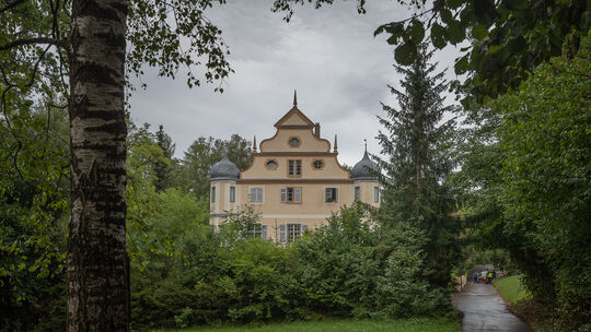 Die Barockfassade des verwunschenen Schlosses der Liebensteiner lugt aus dem Grün am tiefsten Punkt im Ort, wo die Quelle sprude Die Barockfassade des verwunschenen Schlosses der Liebensteiner lugt aus dem Grün am tiefsten Punkt im Ort, wo die Quelle sprude