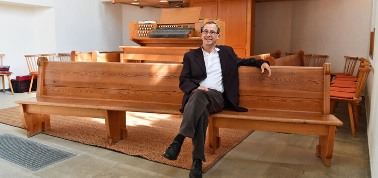 Pfarrer Daniel Trostel auf einer der Bänke. Foto: Markus Brändli