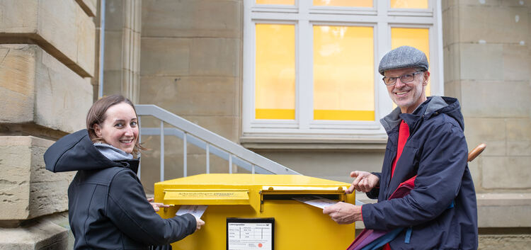 Dana Ettmayer und Ken Christian werfen ihre Briefwahlunterlagen in den Briefkasten am Postplatz. Foto: Carsten Riedl