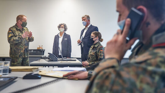 Landrat Heinz Eininger und Dr. Dominique Scheuermann schauen sich die Arbeit der Soldatinnen und Soldaten der Bundeswehr an.Foto