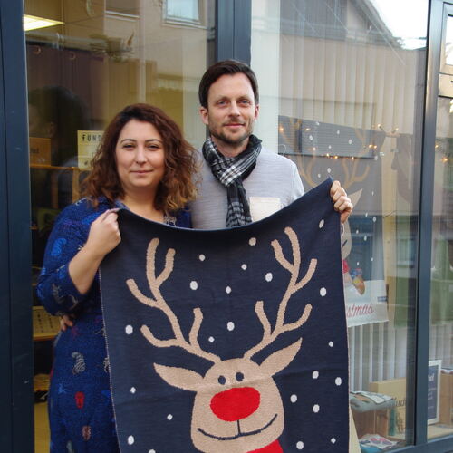 Neziha Brühöfner und ihr Mann Frank mit der Weihnachtsdecke „Roy tut Gutes“, von der zehn Euro an den Hospizdienst im Landkreis
