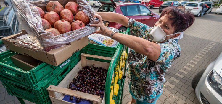 Eine Frau sichtet Lebensmittelkisten. Vieles, was im Supermarkt aussortiert wird, ist zu schade zum Wegwerfen.Foto: Giacinto Car
