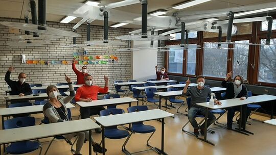 Nach getaner Arbeit nehmen die Eltern an den Schülertischen Platz und präsentieren sich unter den Entlüftungshauben als Mustersc Nach getaner Arbeit nehmen die Eltern an den Schülertischen Platz und präsentieren sich unter den Entlüftungshauben als Mustersc