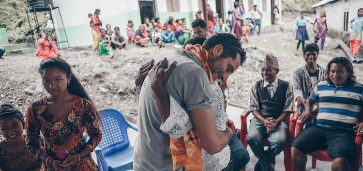 Die Menschen in einem nepalesischen Bergdorf freuen sich über den neuen Brunnen und umarmen Micha Fritz, weil sie endlich sauber