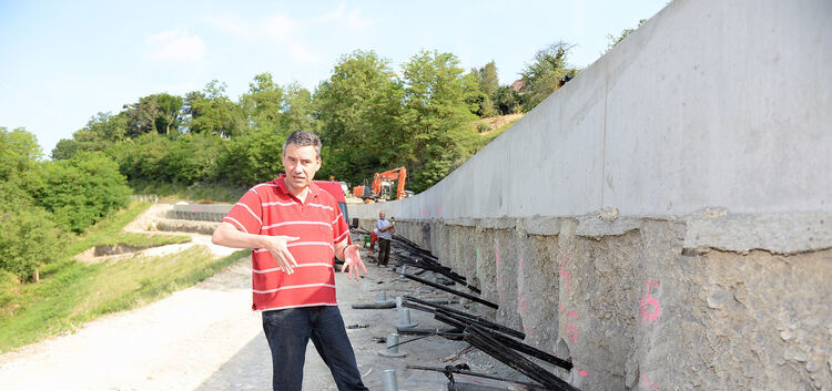 Klaus Ullrich, Baudirektor beim Regierungspräsidium Stuttgart, vor der knapp 100 Meter langen Bohrpfahlwand, aus der noch die An