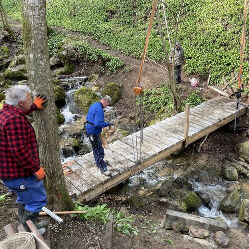 Handarbeit im besten Sinne: Die Albvereins-Mitglieder haben die Brücke über den Zipfelbach gebaut und platziert. Foto: Swen Kauf