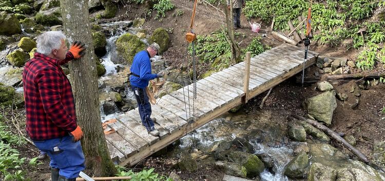 Handarbeit im besten Sinne: Die Albvereins-Mitglieder haben die Brücke über den Zipfelbach gebaut und platziert. Foto: Swen Kauf