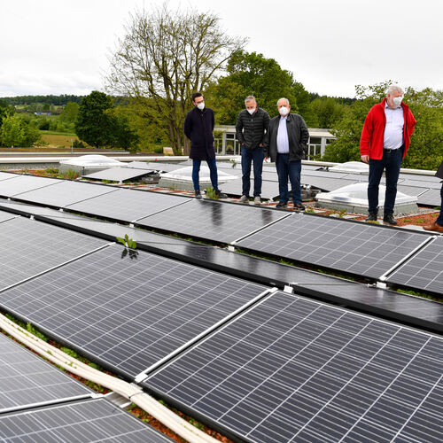 Stadtwerke-Mitarbeiter, Ortsvorsteher und Oberbürgermeister begutachten die Photovoltaik-Anlage auf dem Dach der neuen Eduard-Mö