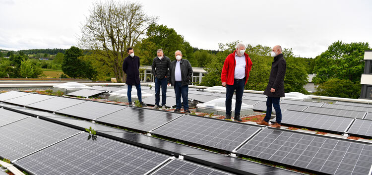 Stadtwerke-Mitarbeiter, Ortsvorsteher und Oberbürgermeister begutachten die Photovoltaik-Anlage auf dem Dach der neuen Eduard-Mö