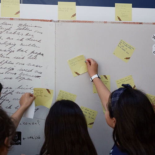 Schülerinnen erarbeiten sich an einer Infotafel Themen rund um Anne Frank. Foto: Gregor Zielke