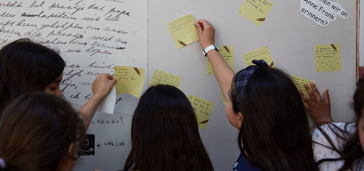 Schülerinnen erarbeiten sich an einer Infotafel Themen rund um Anne Frank. Foto: Gregor Zielke