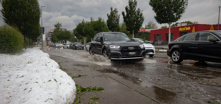 Hagel säumt die überfluteten Straßen. Foto: Carsten Riedl