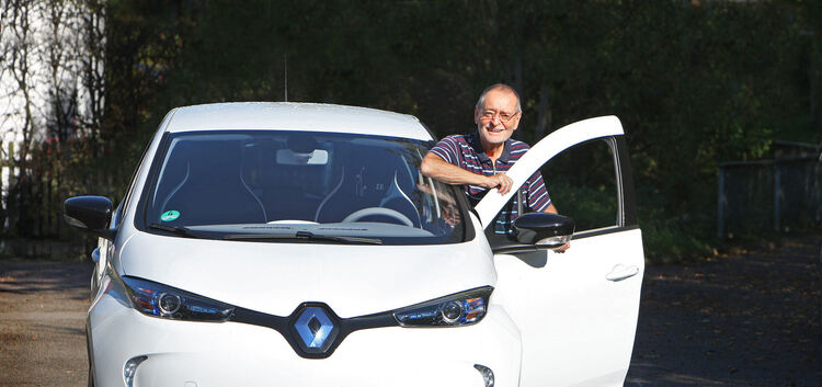 Stolz steht Rolf Lütz (links) neben seinem neuen Rolf Lütz mit seinem Elektroauto.  Foto: Jean-Luc Jacques
