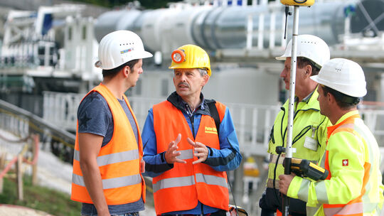 Peter Maile (Zweiter von links) im Gespräch mit Arbeitern auf der Baustelle bei Aichelberg. Auf dem kleinen Foto ist der Diakon