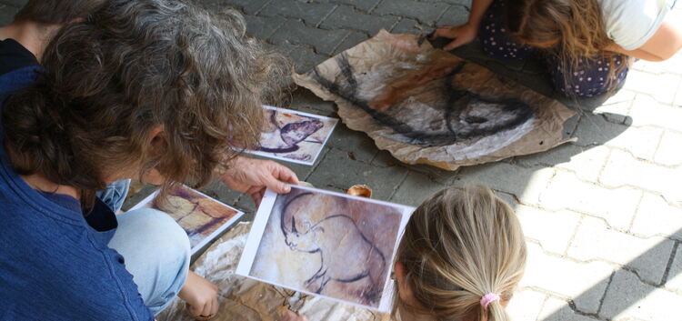 Die Museumspädagogin Heidi Schubert hilft den Kids bei ihrer „Höhlenmalerei“.Foto: Helga Single