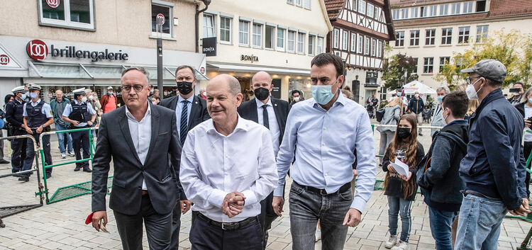 Olaf Scholz läuft, flankiert vom SPD-Landespolitiker Andreas Stoch (links) und dem SPD-Bundestagskandidaten Nils Schmid, in der