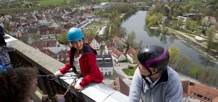 Gleich geht es in die Tiefe: Annette Krause und Peter Rieger lassen sich vom Turm der Stadtkirche abseilen. Foto: Holzwarth