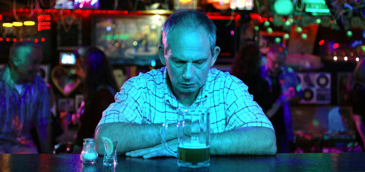 Auf diesem Szenenbild sitzt Michael Lott in der Hauptrolle als Werner Schmidt gerade trübsinnig an einer Bar. Für die Premierenz