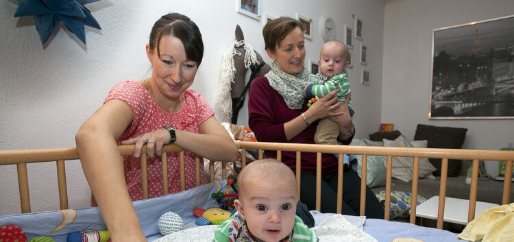 Schauen immer neugieriger aus der Wäsche: Die eineiigen Zwillinge Leonard und Niklas mit Mutter Melanie Reim und der Ehrenamtlic