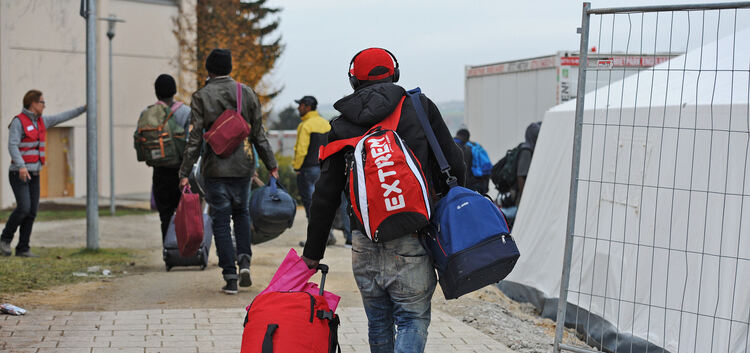Mit Rucksäcken und Taschen beladen machen sich die Männer auf in ihre neue Unterkunft.Foto: Markus Brändli