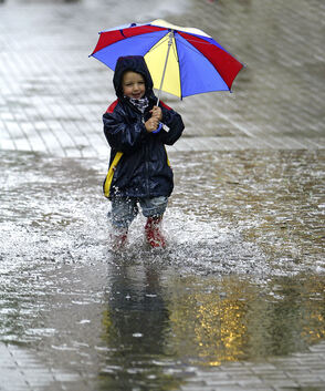 Regen - Wetter, Pfütze, Wasser, Kind mit Gummistiefel und Regenschirm, Spaß im Regen