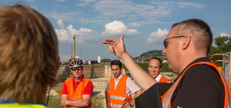 Jörg Wüst, Projektleiter der ARGE, zeigt Gemeinderat und Verwaltungsspitze bei einer Radtour entlang der Neubaustrecke, wo die B