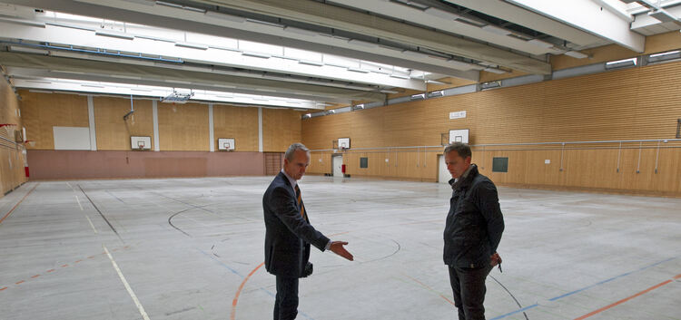 Thomas Eberhard (links) und Clemens Erath vom Landratsamt begutachten den Sporthallenboden. Foto: Jürgen Holzwarth