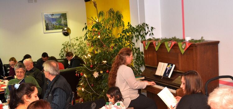 Weihnachtslieder unterm Tannenbaum mit Klavierbegleitung. - Eine willkommene Gelegenheit für Menschen, die am Heiligabend nicht